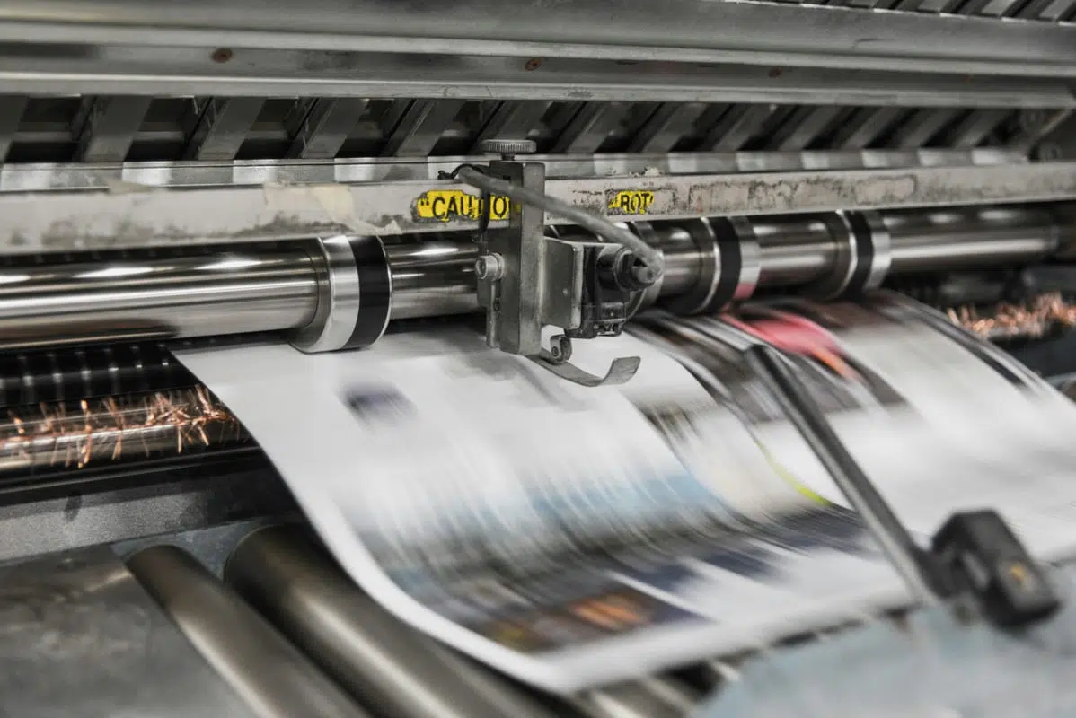 Panfletos: Tamanhos, Papel, Preços e Como Criar (Guia 2026) 7 Máquina de impressão offset a imprimir folhas em produção